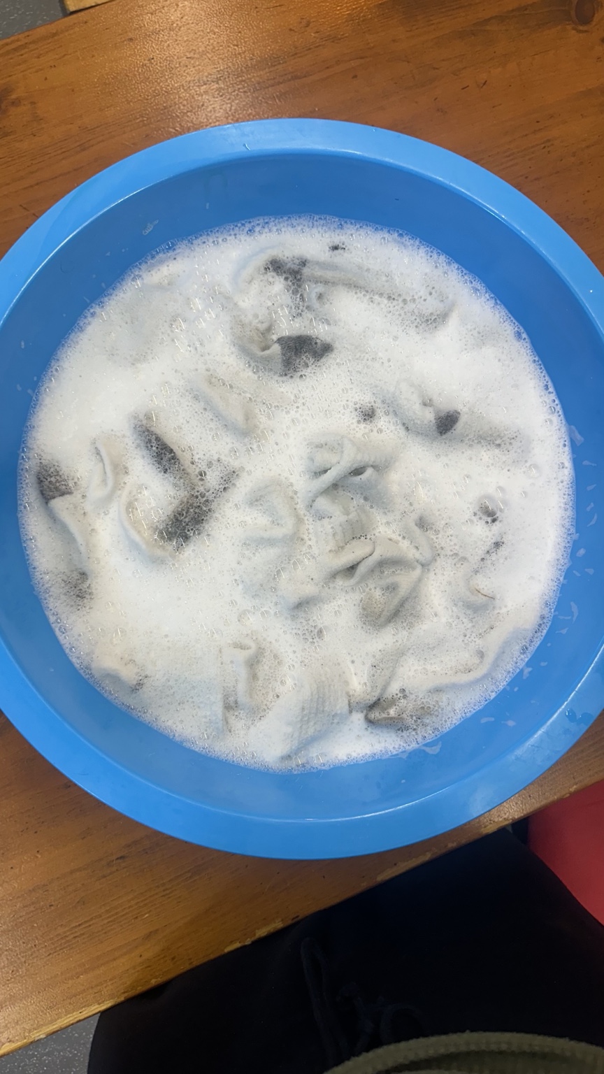 Clothes soaking in a blue basin during laundry care